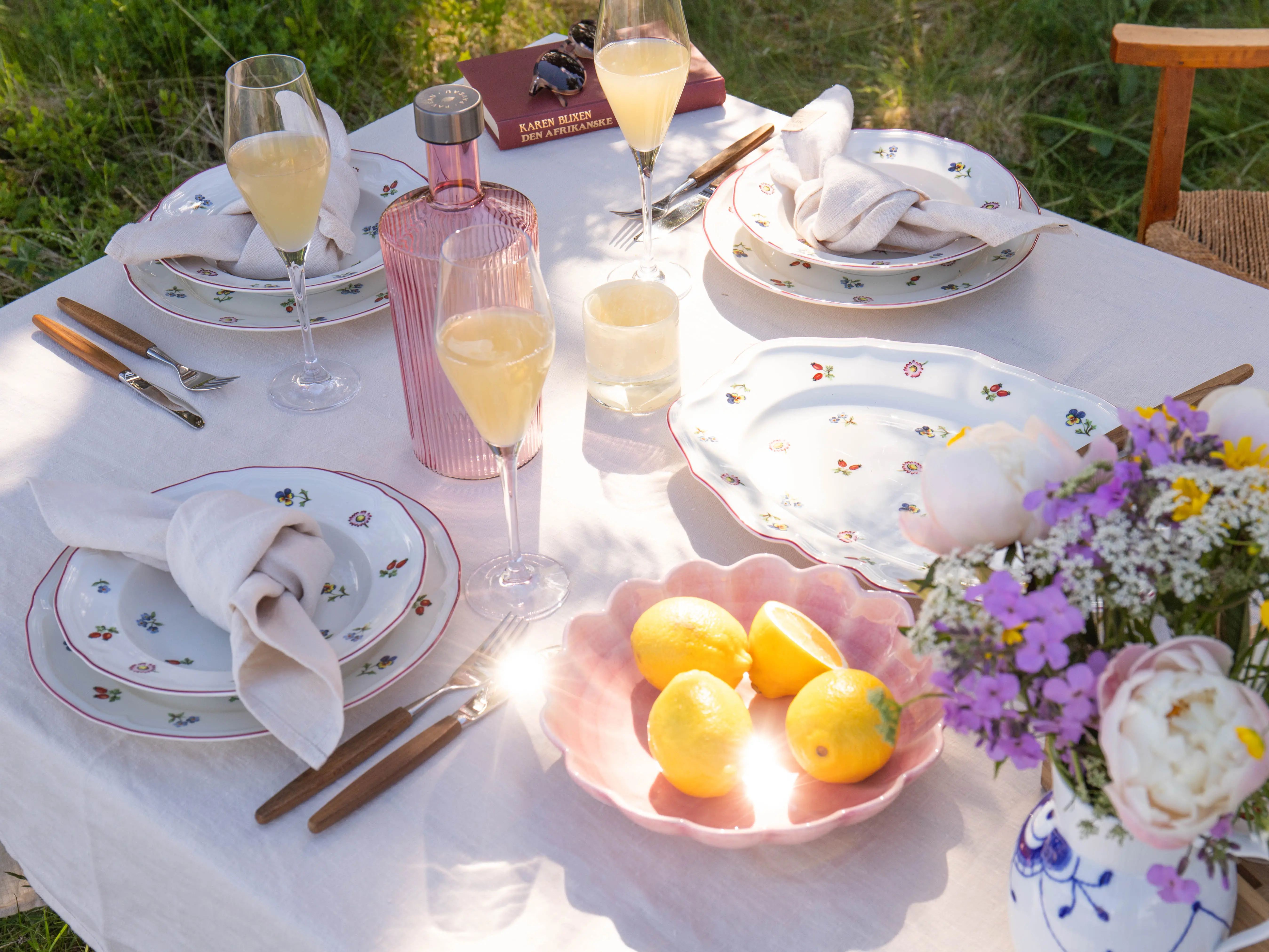 Petite Fleur sommerbord i kveldslys med blomster og sitroner